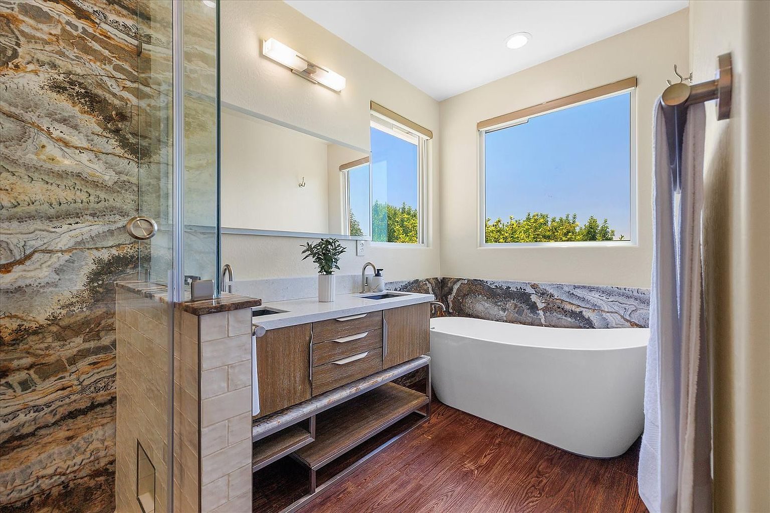 Primary bathroom with floor-to-ceiling onyx wall and soaking tub